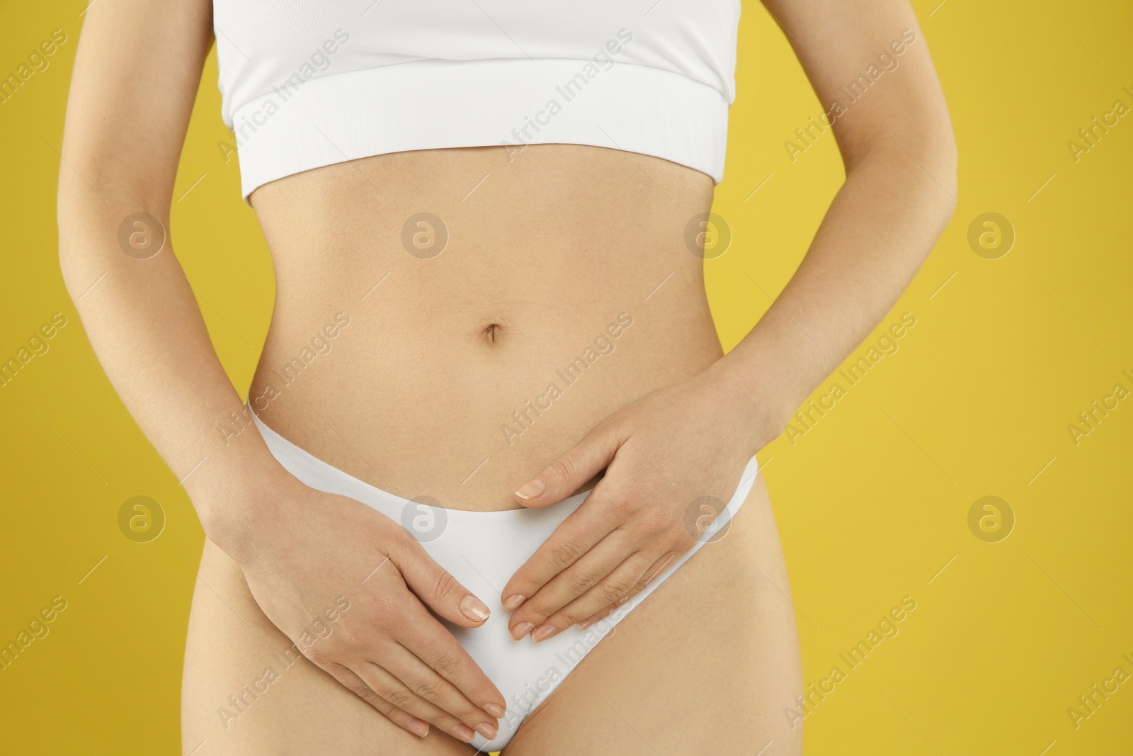 Photo of Gynecology. Woman in underwear on yellow background, closeup