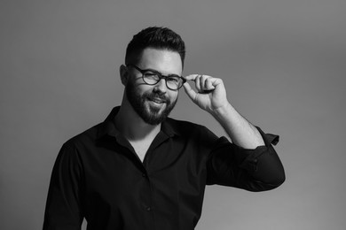 Portrait of handsome bearded man on grey background. Black and white effect