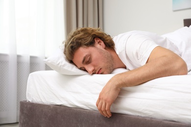 Photo of Handsome young man sleeping on pillow at home. Bedtime