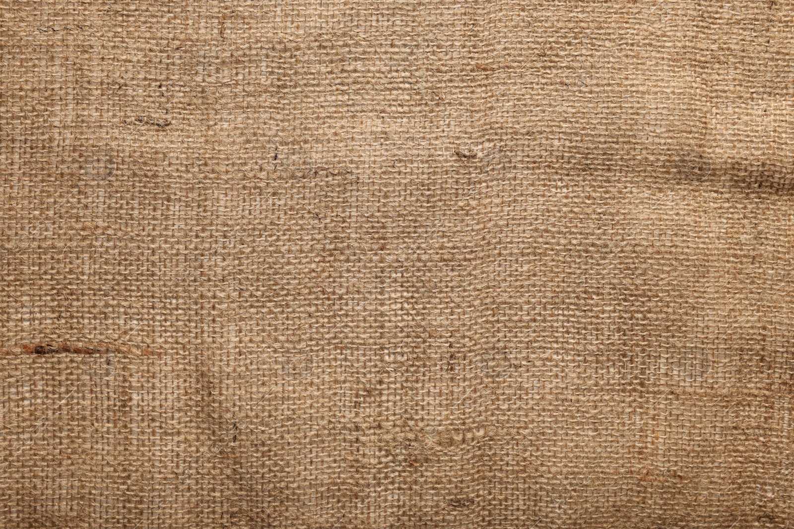 Photo of Texture of natural burlap fabric as background, top view