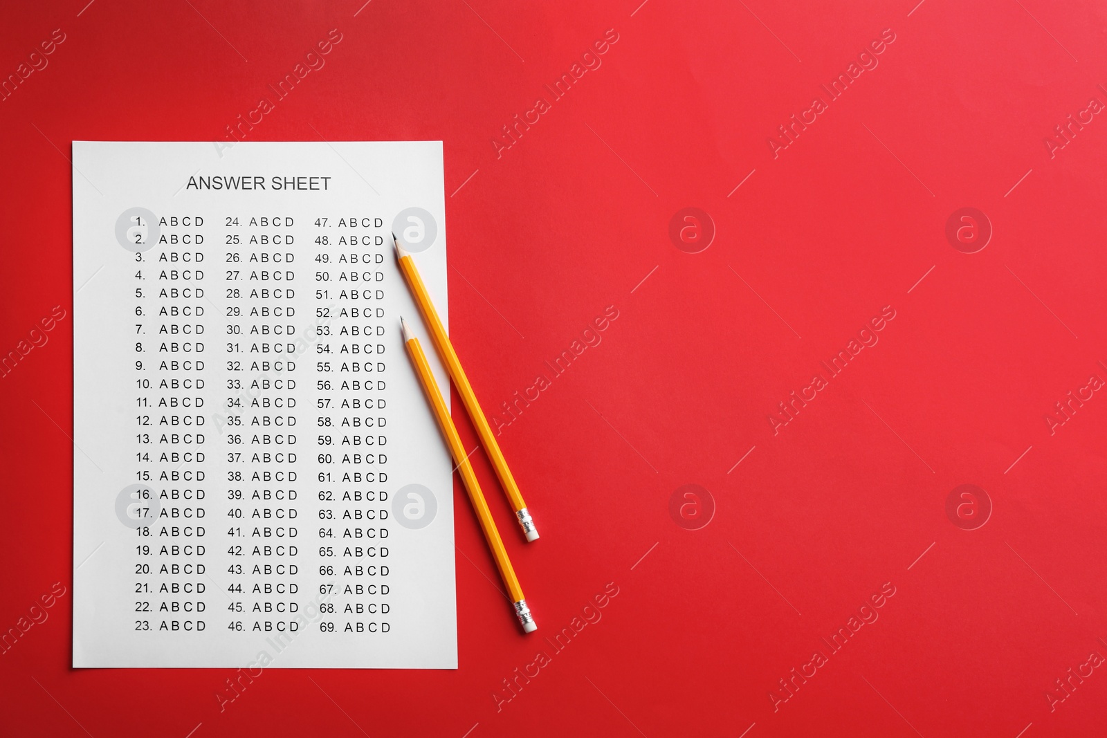 Photo of Answer sheet and pencils on color background, top view with space for text