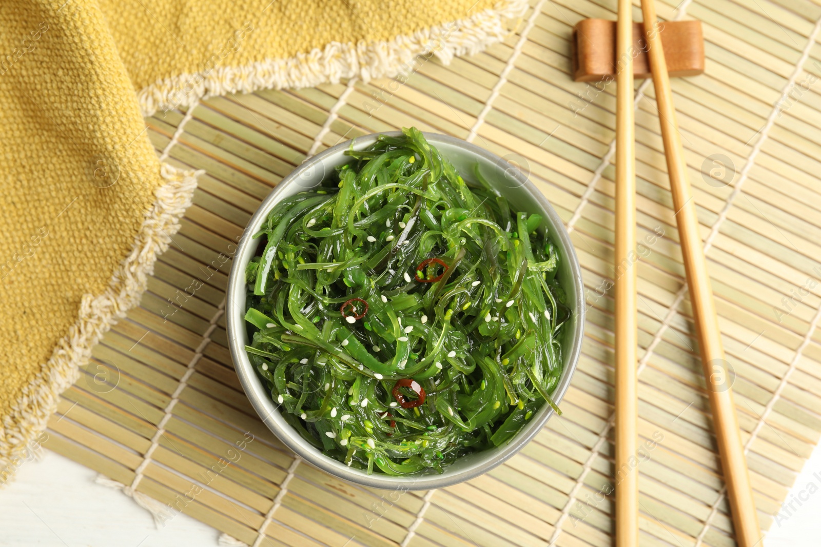 Photo of Japanese seaweed salad served on table, flat lay