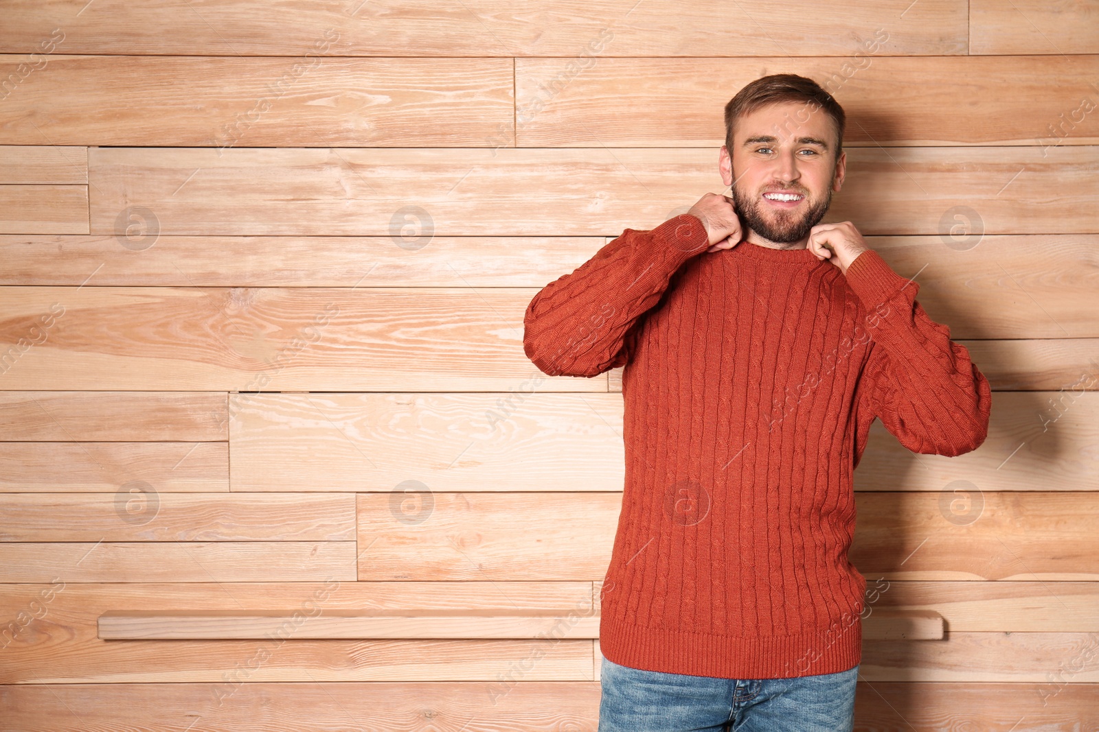 Image of Handsome man wearing warm sweater on wooden background. Space for text