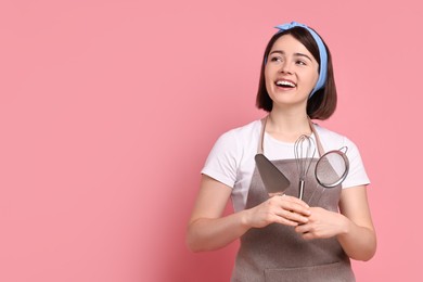 Photo of Happy confectioner with professional tools on pink background, space for text