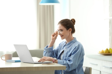 Image of Young woman working on laptop at home