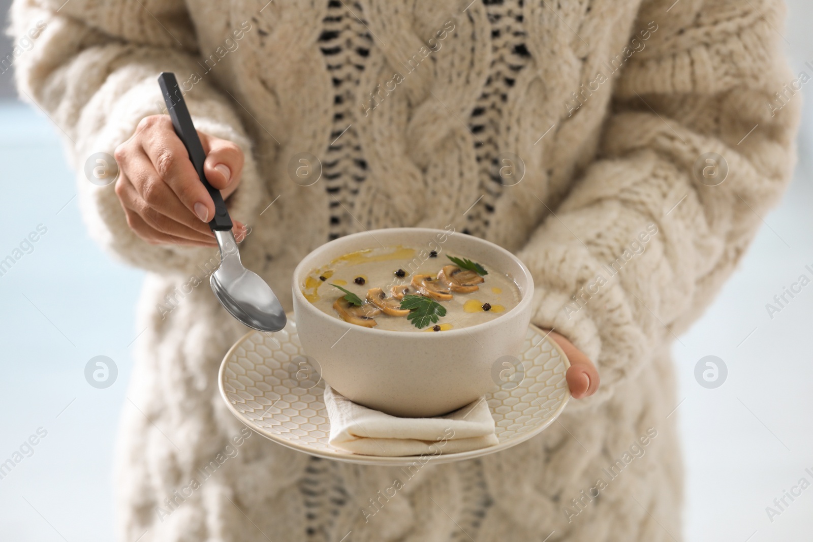 Photo of Young woman with bowl of cream soup, closeup