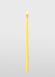 Image of One burning church candle on light background