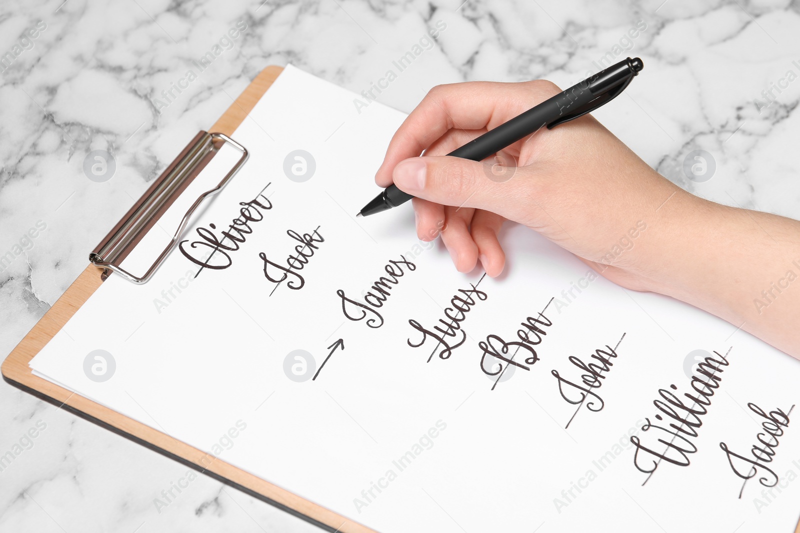 Photo of Woman choosing baby name at white marble table, closeup