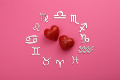 Photo of Zodiac signs and red hearts on pink background, flat lay
