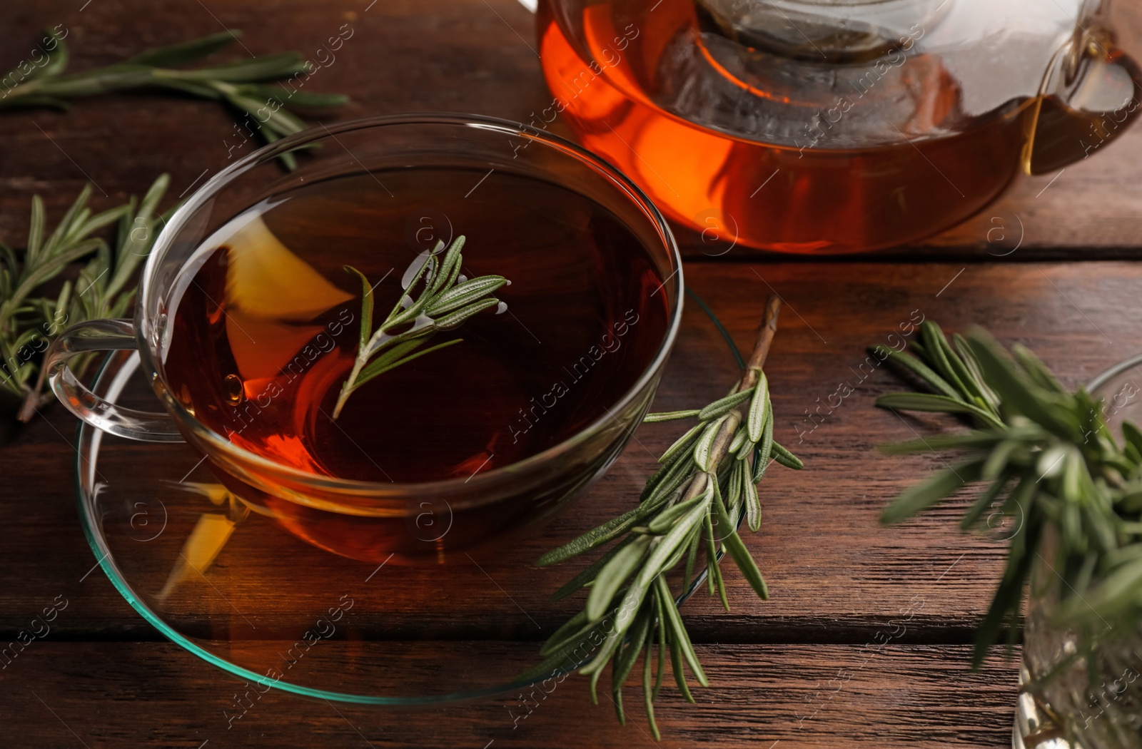 Photo of Aromatic herbal tea with rosemary on wooden table