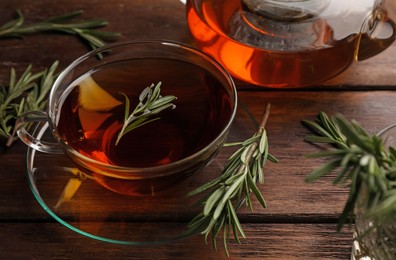 Aromatic herbal tea with rosemary on wooden table