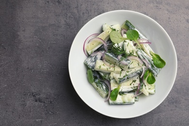 Photo of Plate with creamy cucumber salad on table, top view. Space for text