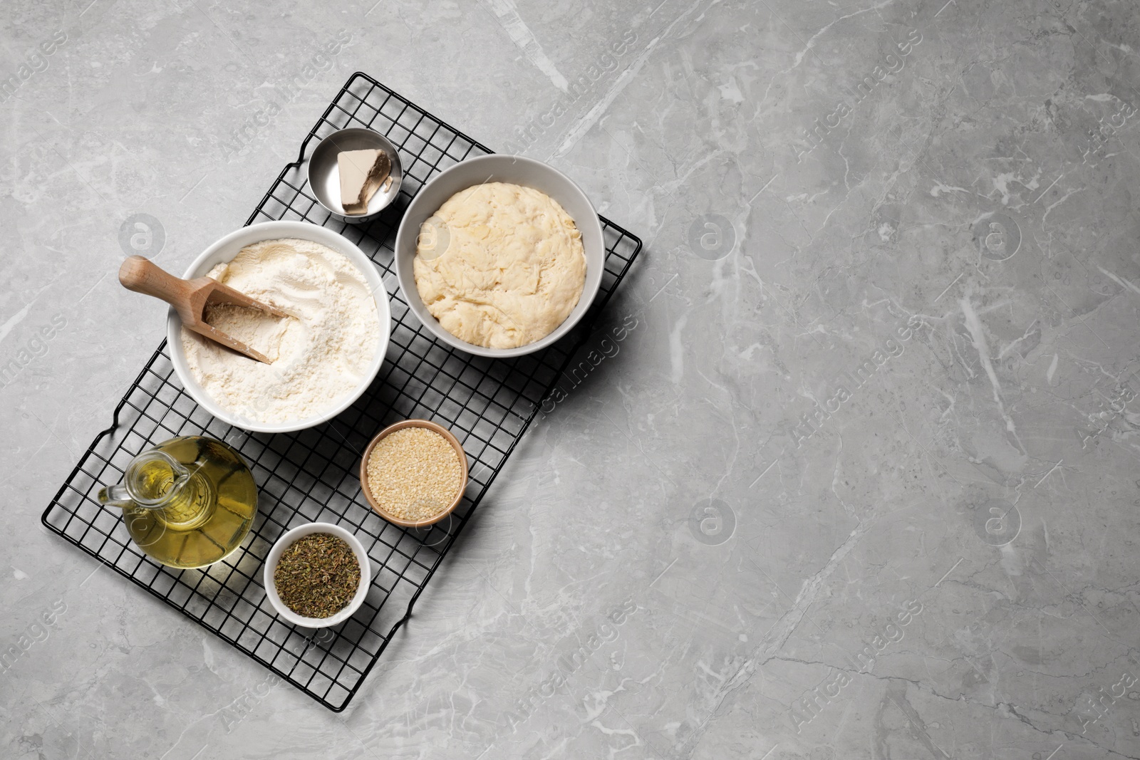 Photo of Cooking grissini. Different ingredients on grey marble table, flat lay. Space for text