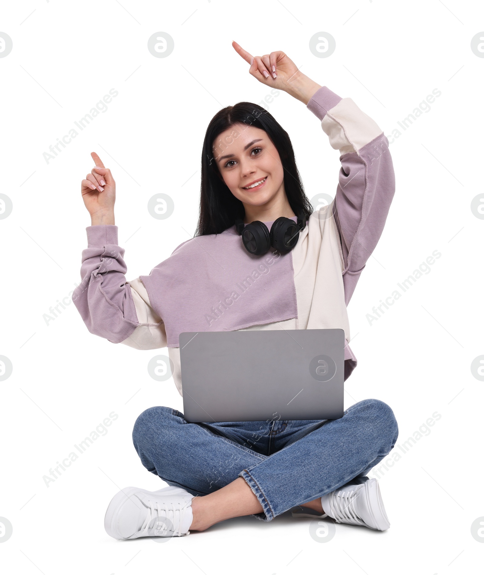 Photo of Smiling student with laptop pointing at something on white background