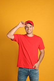 Happy man in red cap and tshirt on yellow background. Mockup for design
