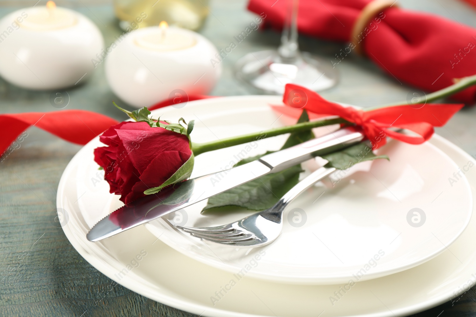 Photo of Beautiful table setting for Valentine's Day dinner with rose on wooden background, closeup