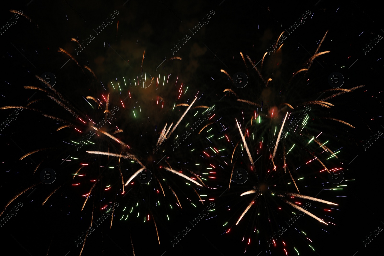 Photo of Beautiful fireworks lighting up night sky outdoors