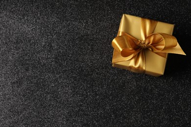 Beautifully wrapped gift box on black background, top view. Space for text