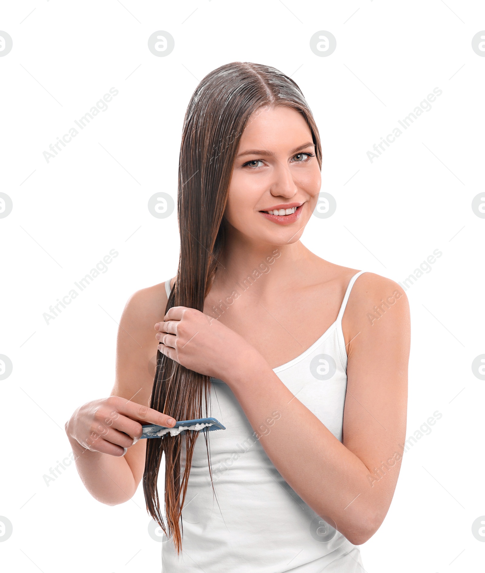 Photo of Young woman brushing hair after applying mask on white background