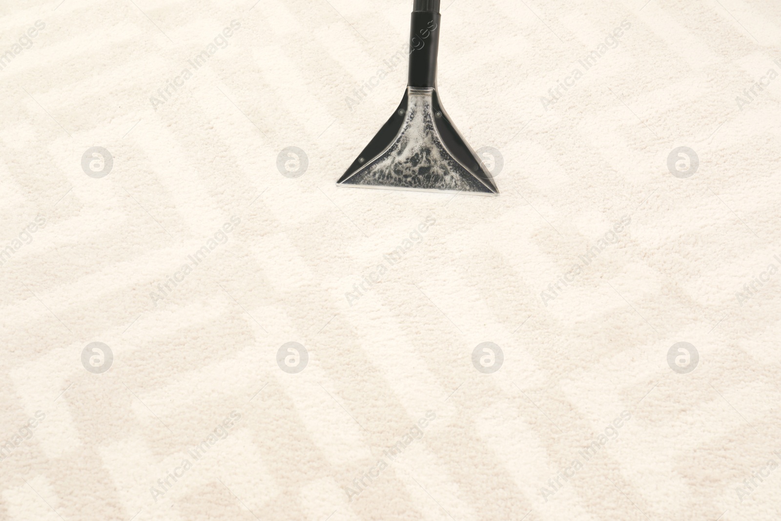 Photo of Removing dirt from carpet with vacuum cleaner indoors, closeup. Space for text