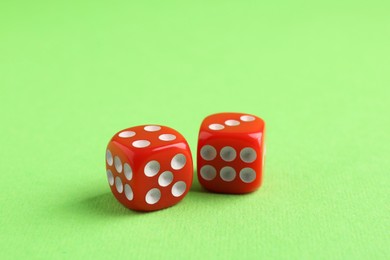 Two red game dices on green background, closeup