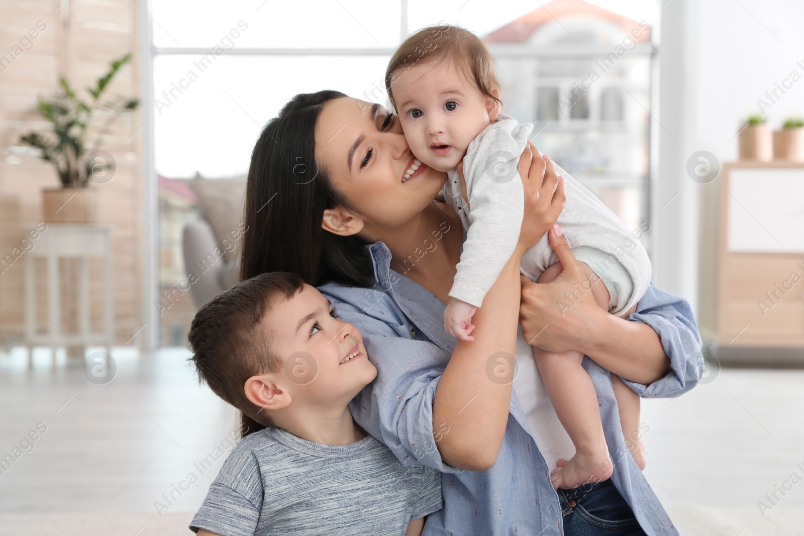 Photo of Happy mother with her cute children at home. Family time