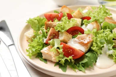 Photo of Delicious fresh Caesar salad on plate, closeup