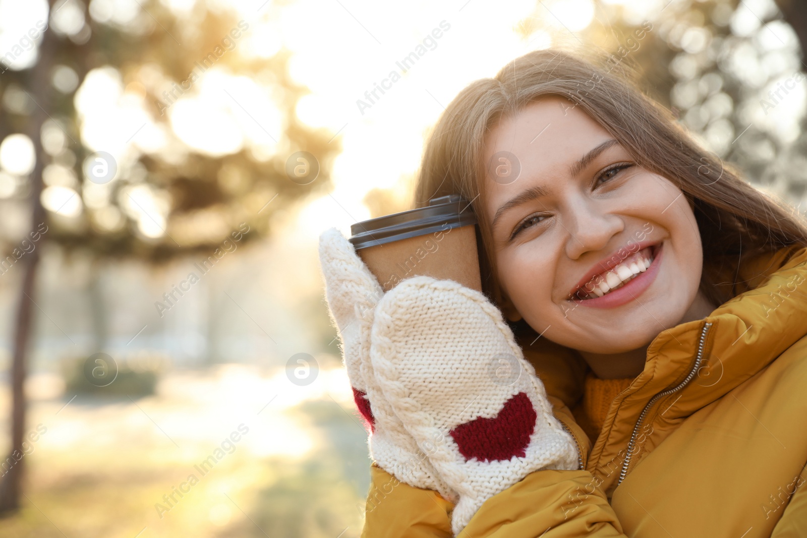 Photo of Young woman with cup of coffee in morning outdoors