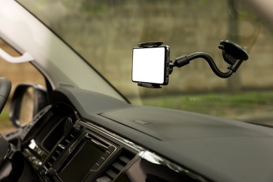 Photo of Car holder with modern mobile phone on windshield of automobile. Mockup for design