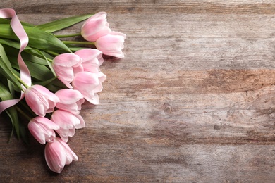 Photo of Beautiful tulips for Mother's Day on wooden background, top view