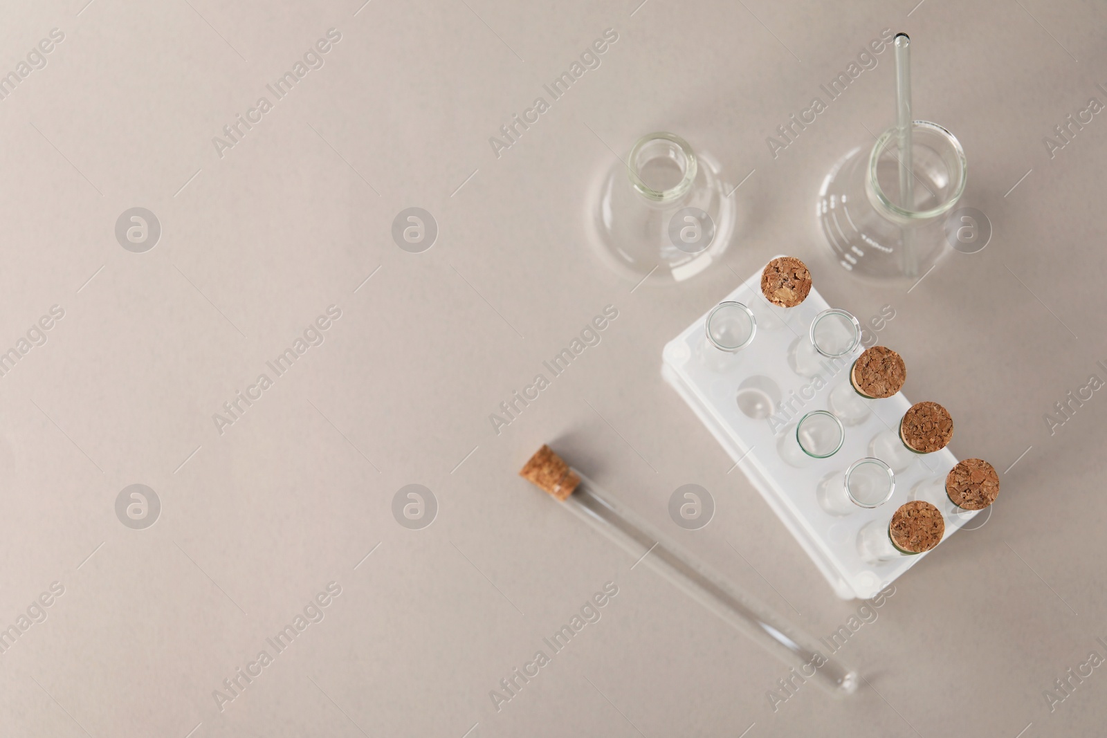 Photo of Different laboratory glassware on beige background, flat lay. Space for text