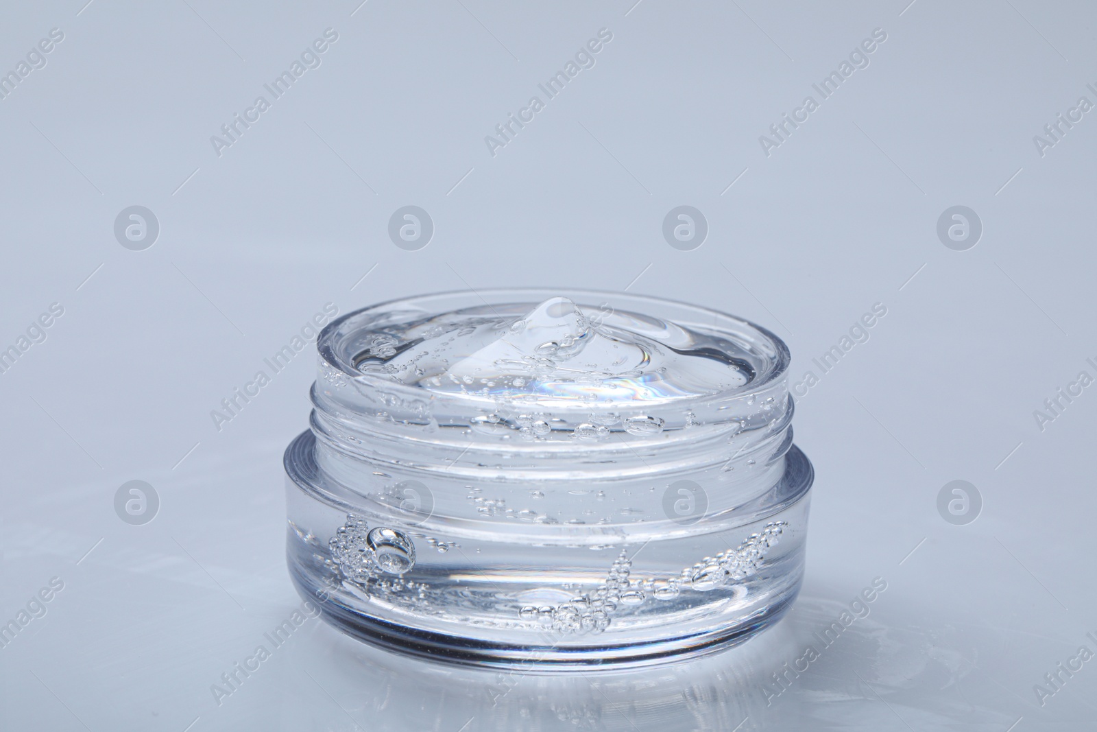 Photo of Jar of transparent cosmetic gel on light background