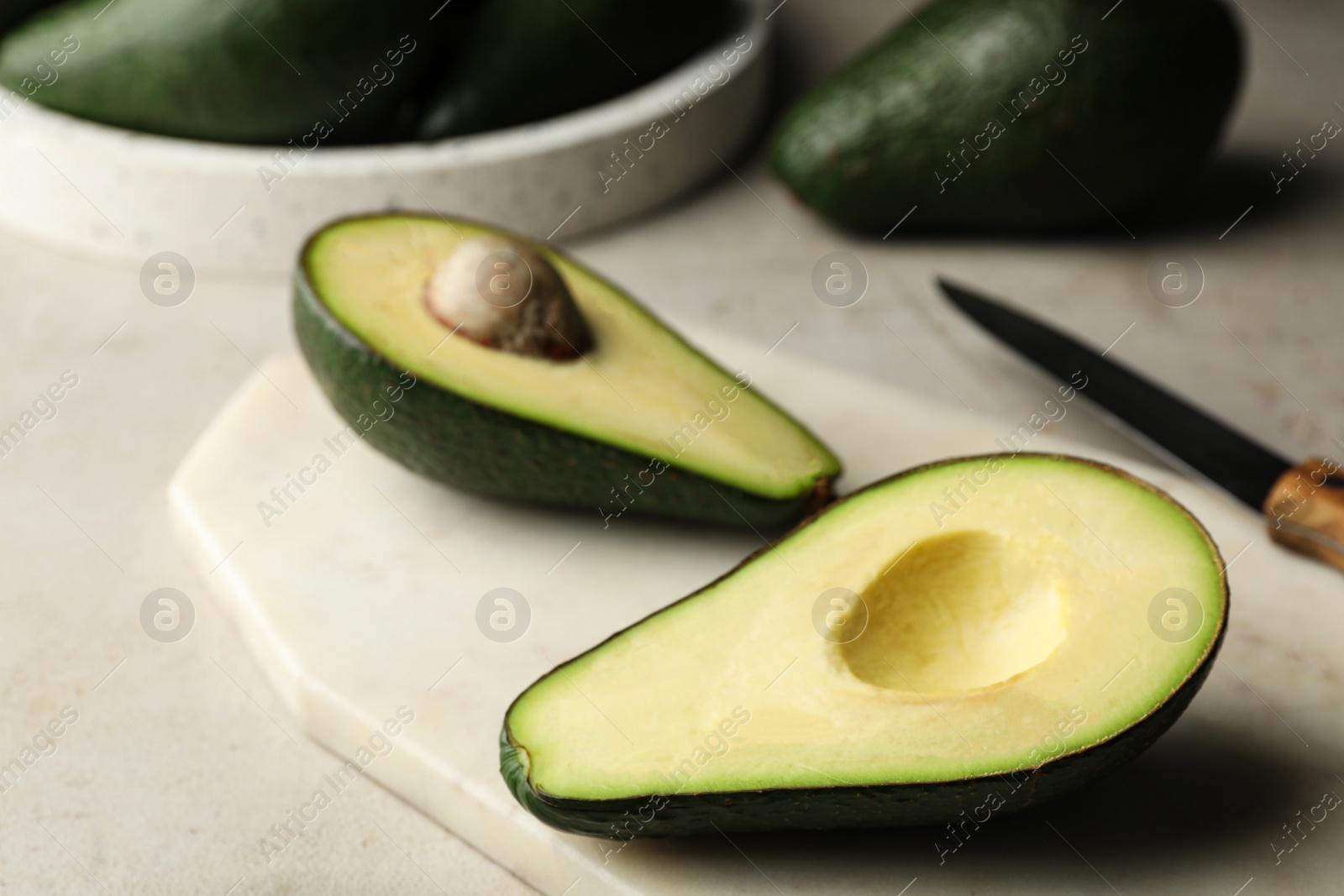 Photo of Halves of delicious ripe avocado on table