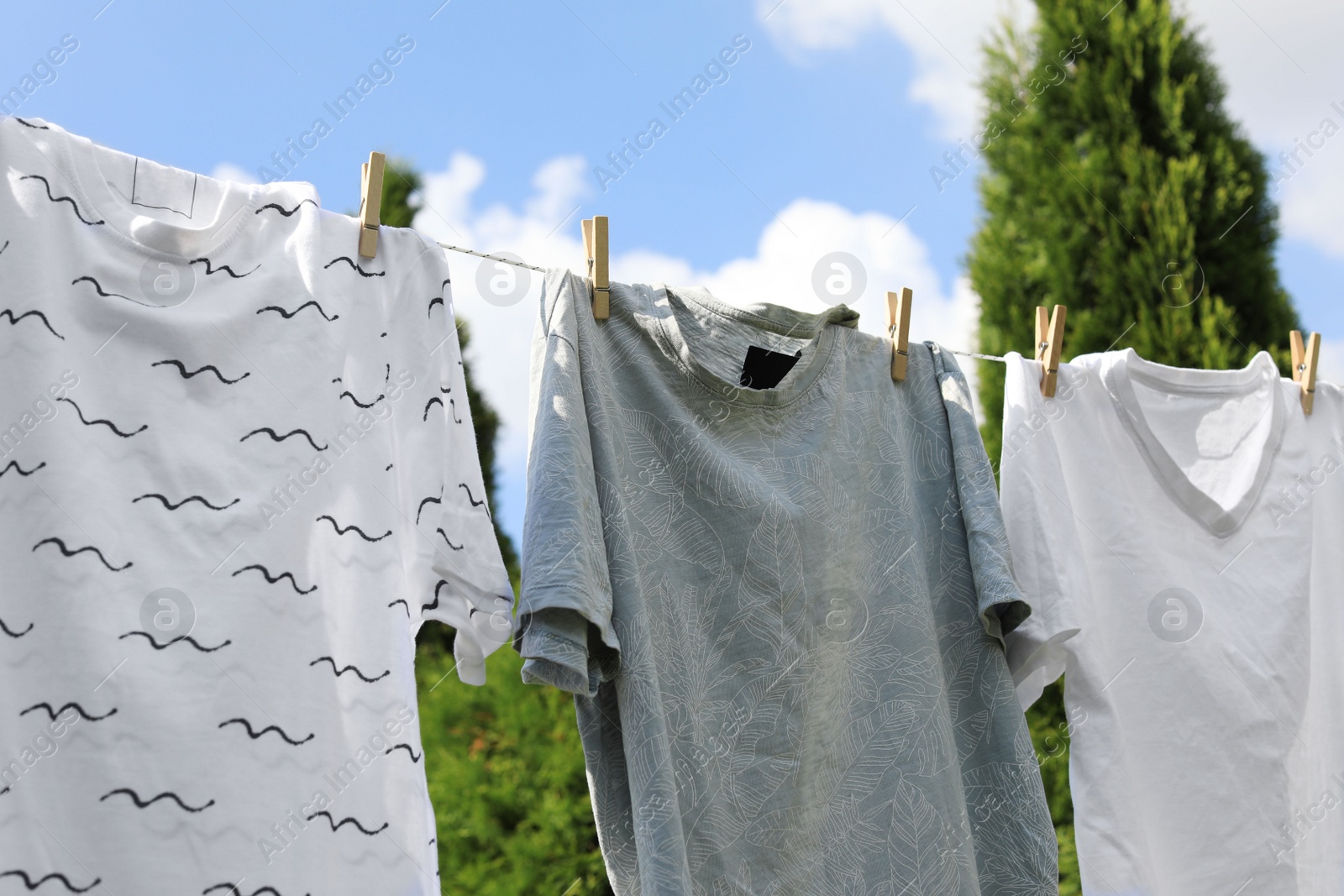 Photo of Washing line with clean clothes outdoors. Drying laundry outside