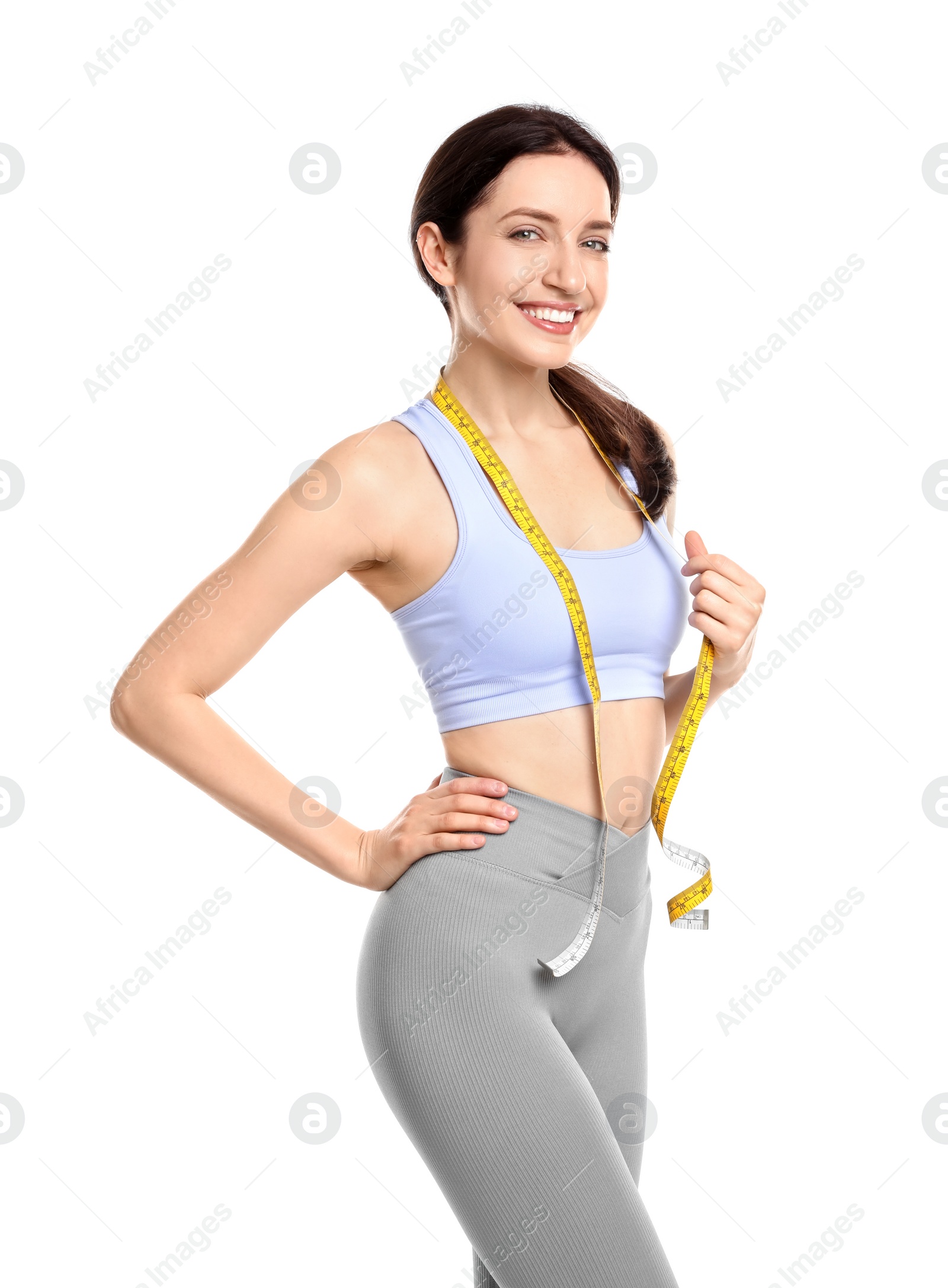 Photo of Happy young woman with measuring tape showing her slim body against white background