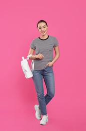 Photo of Beautiful young woman with stylish leather backpack on pink background