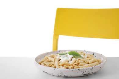 Photo of Delicious penne pasta with sauce served on light table