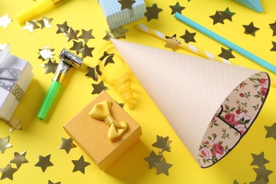 Flat lay composition with party hats on yellow background