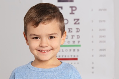 Portrait of cute little boy visiting children's doctor, space for text. Eye examination