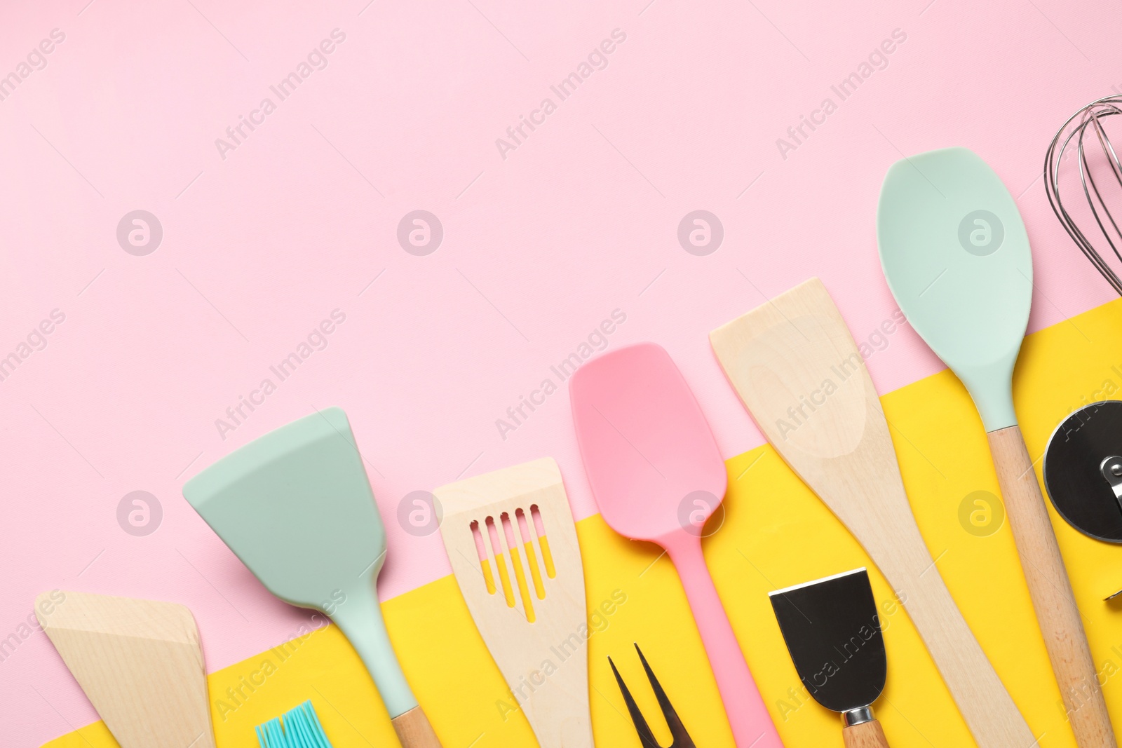 Photo of Different spatulas and other kitchen utensils on color background, flat lay. Space for text