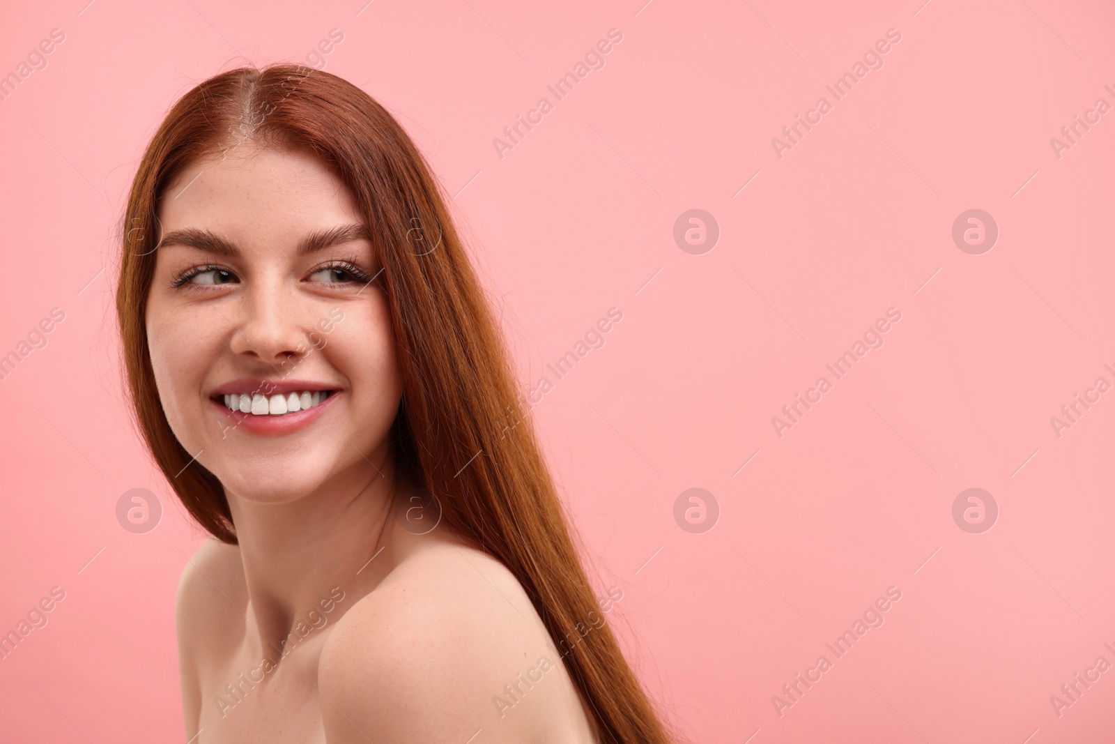 Photo of Portrait of smiling woman with freckles on pink background. Space for text