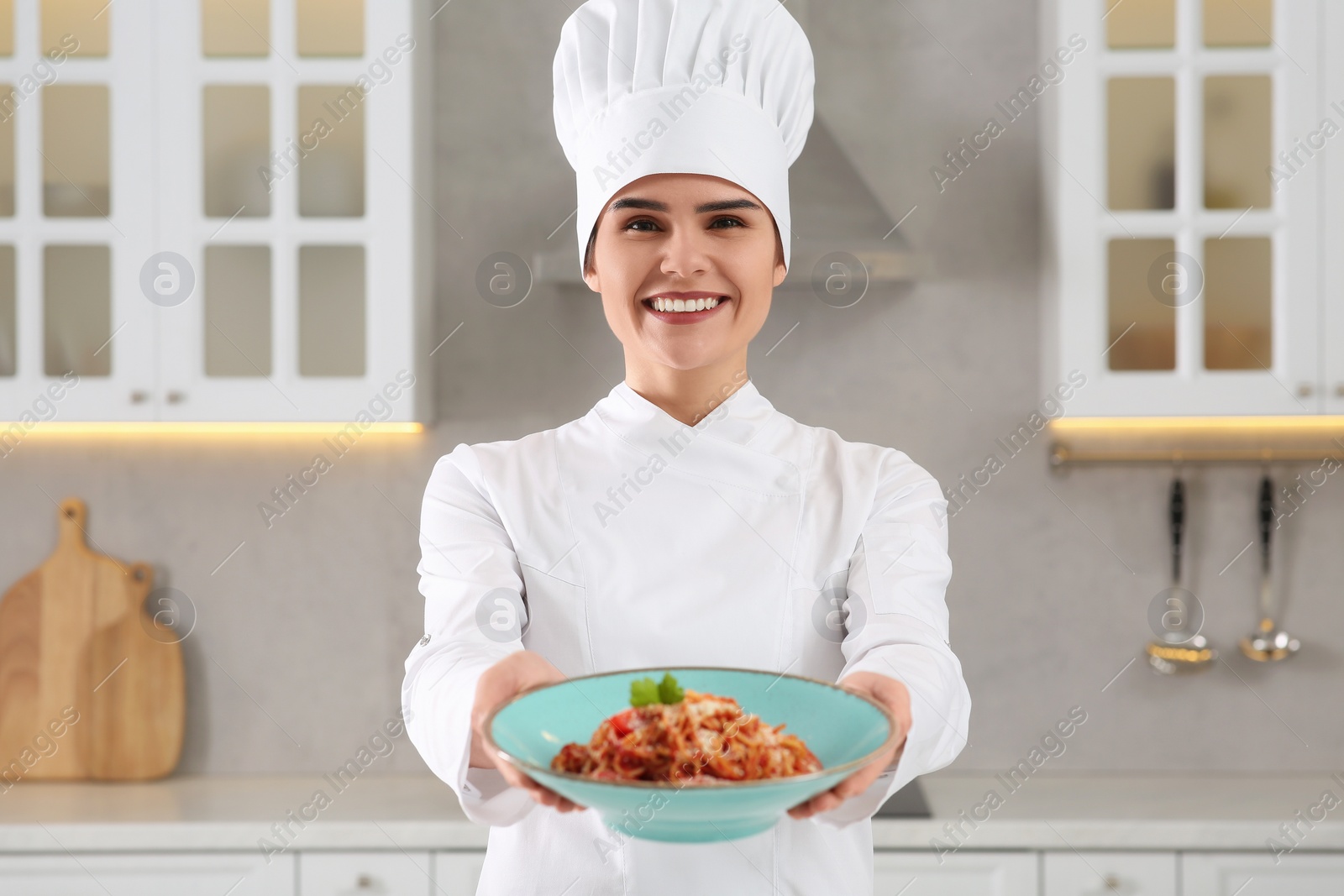 Photo of Professional chef presenting delicious spaghetti in kitchen