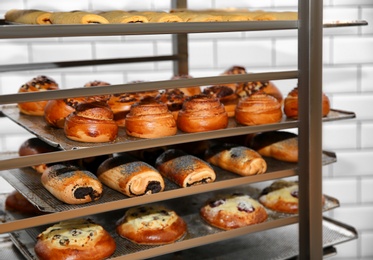 Rack with fresh pastries in bakery workshop