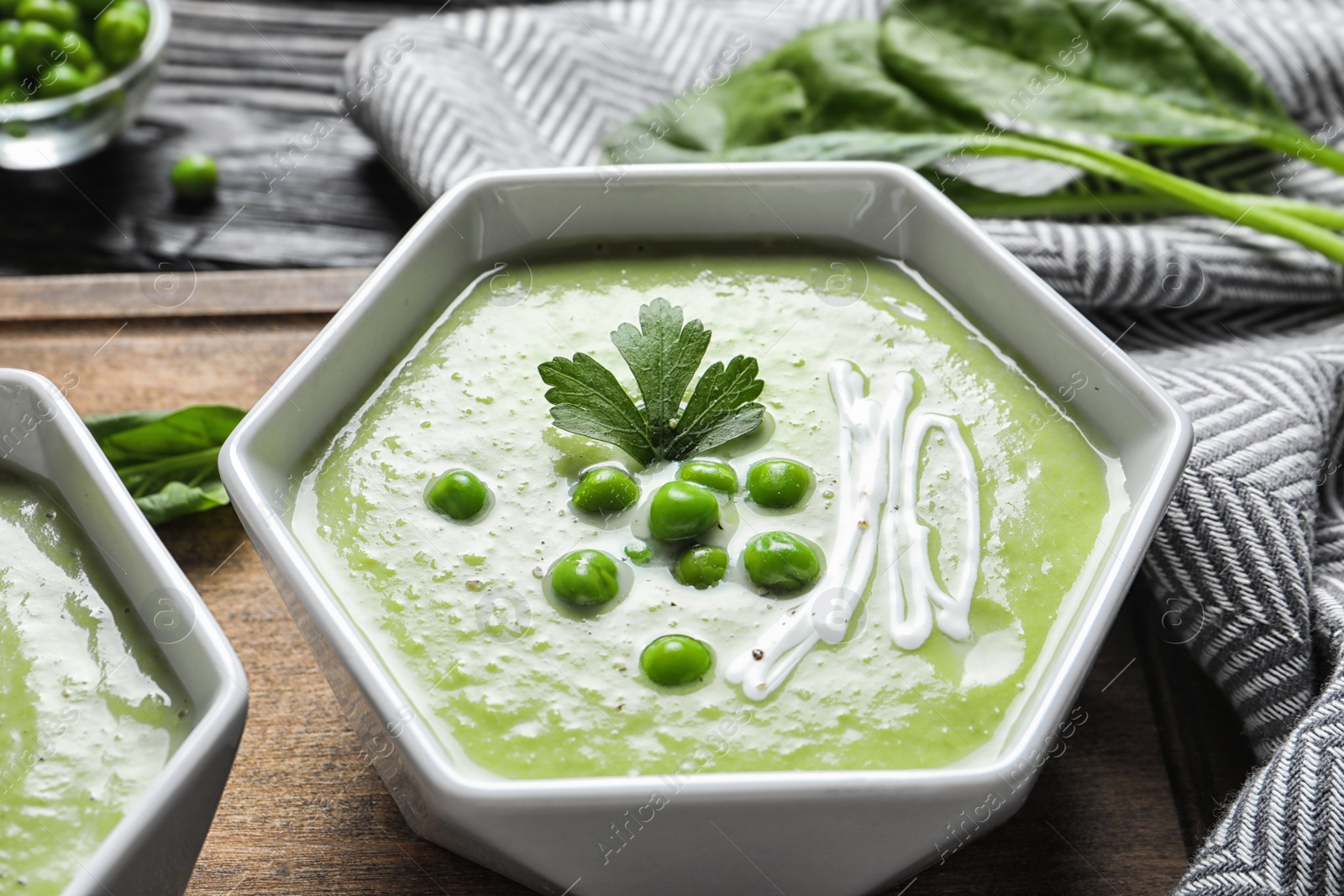 Photo of Fresh vegetable detox soup made of green peas in dish on board