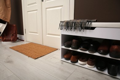Photo of Shelving unit with shoes and door mat in hall