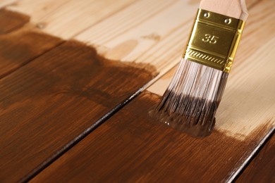 Photo of Applying wood stain onto wooden surface, closeup. Space for text
