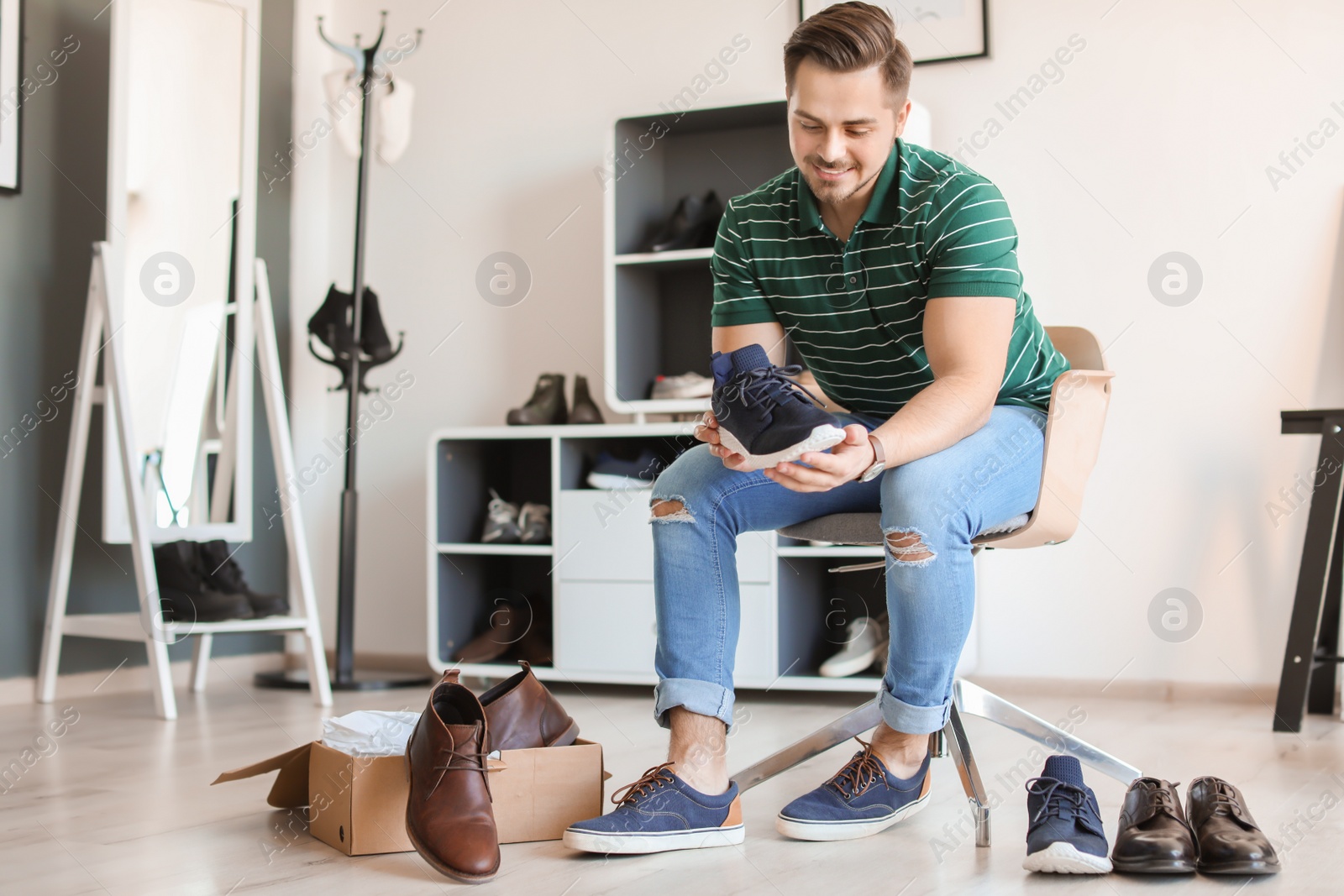 Photo of Young man trying on shoes in store