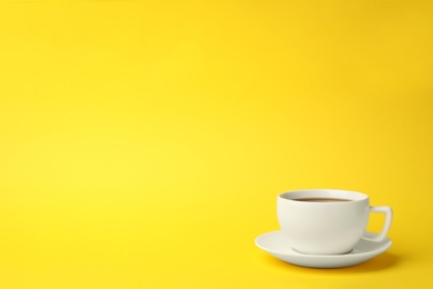 White ceramic cup with hot aromatic coffee on color background