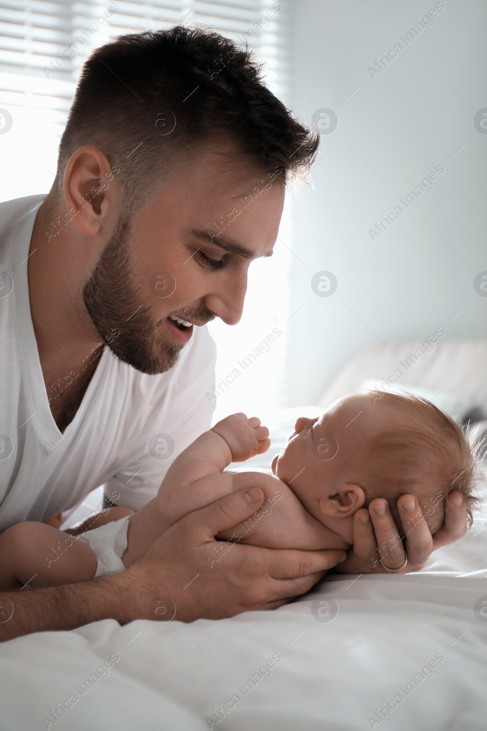 Photo of Father with his newborn son at home