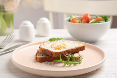 Photo of Delicious breakfast with fried egg, toasted bread and arugula served on white wooden table